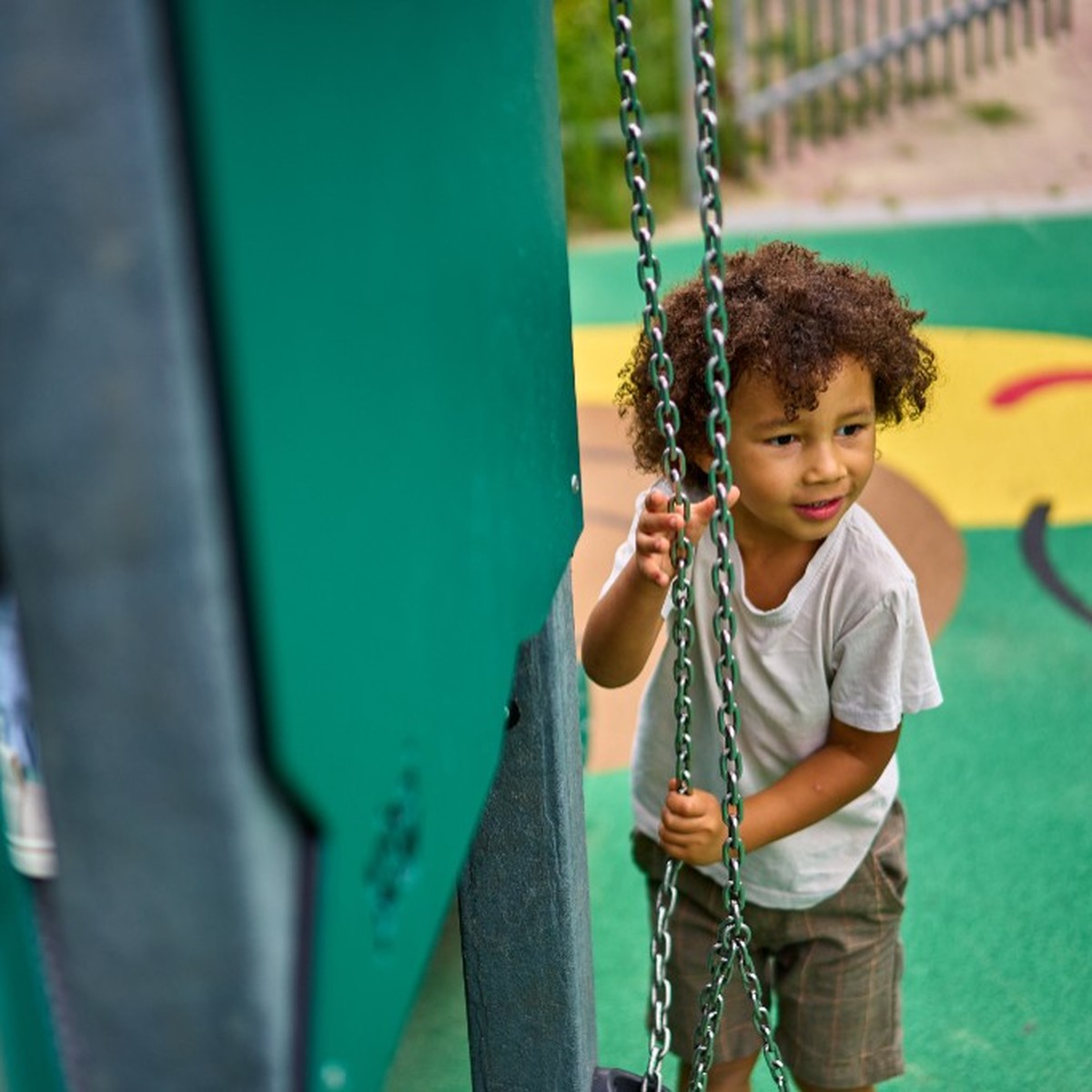 Child playing beside recycled playground equipment